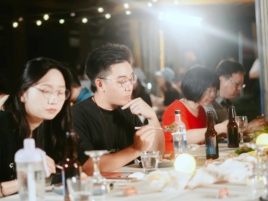 夜晚燈串下的長桌餐會，來賓正在用餐